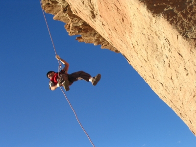 Riziko - risk - horolezec - člověk visící na laně na skále
