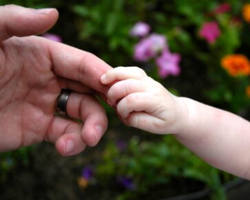 Ruce - dětská ruka drží prst