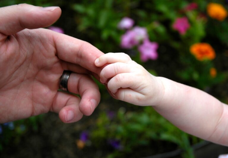 Ruce - dětská ruka drží prst