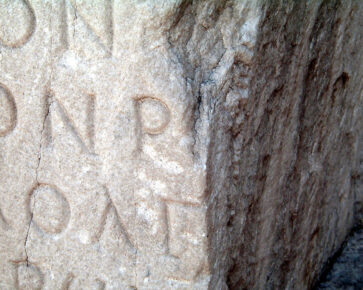 Řecká písmena vytesaná do kamenného kvádru
